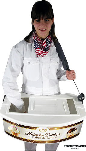 Una bandeja de venta tipo "belly tray" blanca cargada con diversos helados y polos de colores, equipada con correas de transporte cómodas para vender en playas y parques.